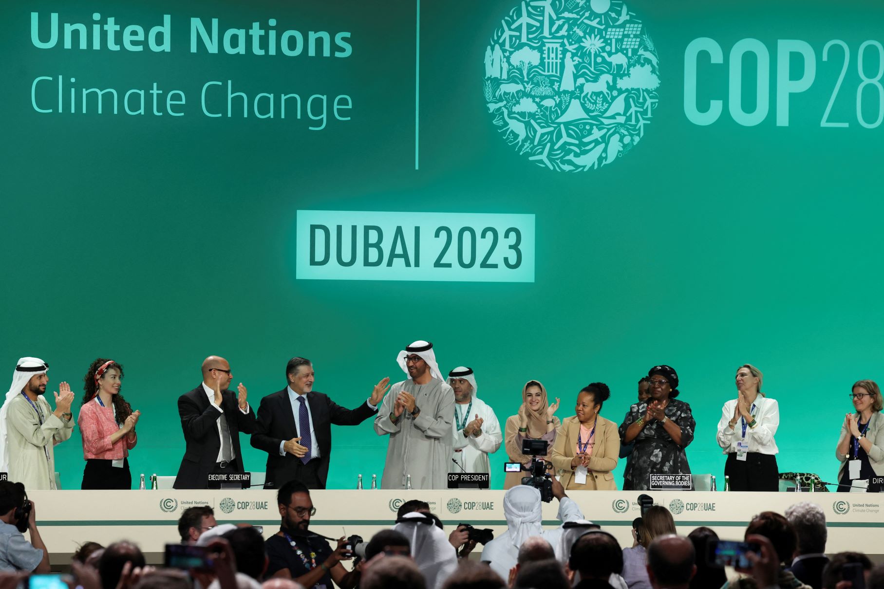 COP28 President Sultan Ahmed Al Jaber stands and applauds on stage with other dignitaries in front of a giant green backdrop at the plenary at the UN Climate Change Conference in Dubai, United Arab Emirates on December 13, 2023. REUTERS/Amr Alfiky