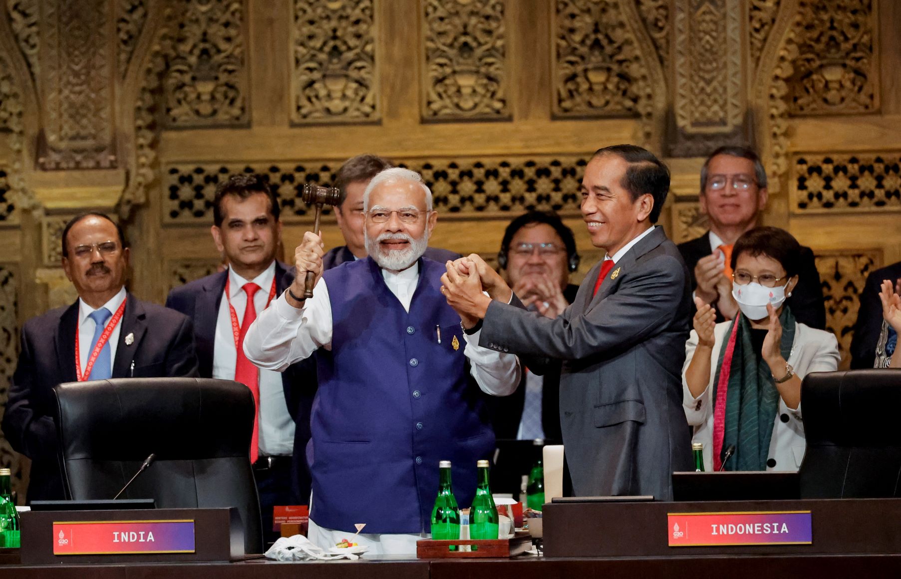 India's Prime Minister Narendra Modi, raising a gavel in one hand and Indonesia's President Joko Widodo’s hand in his other, stand and smile during the handover ceremony at the G20 Leaders' Summit in Bali, Indonesia on November 16, 2022. 