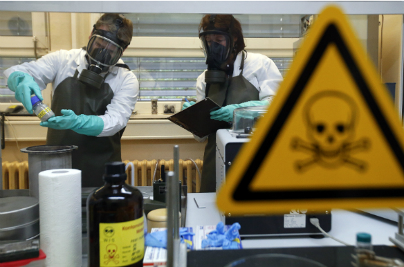 Employees of the Research Institute for Protective Technologies, Nuclear, Biological and Chemical Protection (WIS) inspect an infected dummy sample during a demonstration in Munster October 15, 2013. (Fabrizio Bensch/Reuters)
