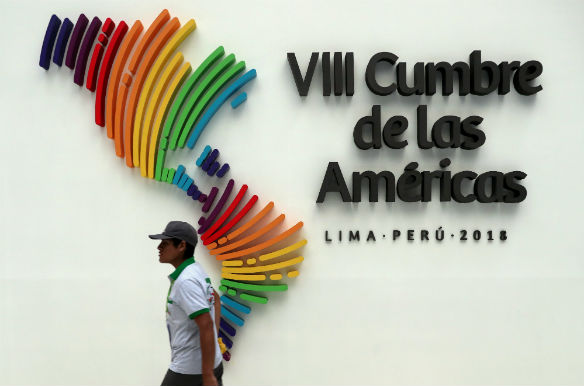 A man walks past an official logo the Eighth Summit of the Americas in Lima, Peru on April 14, 2018. MARCOS BRINDICCI/REUTERS