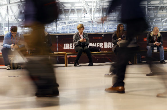 Visitors at the Mobile World Congress look at their mobile phones in Barcelona, February 24, 2014. (Albert Gea/Reuters)