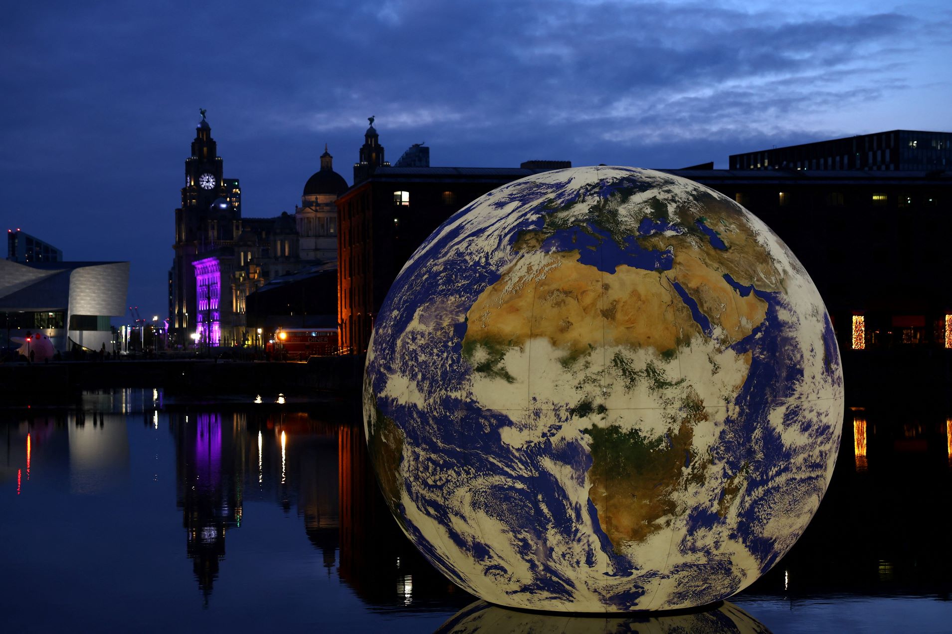 Luke Jerram's “Floating Earth,” an art installation of an illuminated globe sitting in water at night as part of the Eurovision celebrations in Liverpool, England on April 28, 2023. REUTERS/Molly Darlington