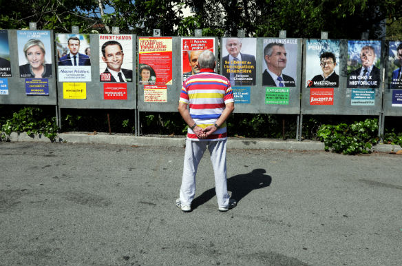 A man looks at campaign posters of the eleven candidates who run in the 2017 French presidential election in Saint Andre de La Roche, near Nice, France, April 10, 2017. (Eric Gaillard/Reuters)